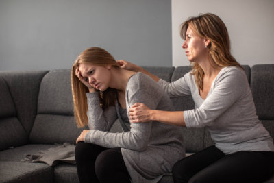 depressed teen suffering from anxiety being taken care of by her caring mother