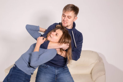 people, abuse and violence concept - aggressive man strangling his wife