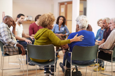 people attending self help therapy group meeting In community center