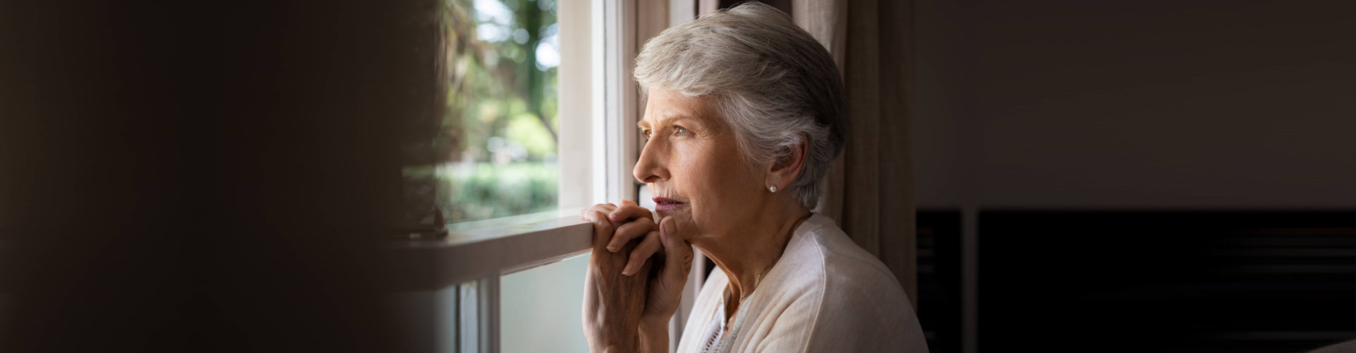 elder woman looking through the window