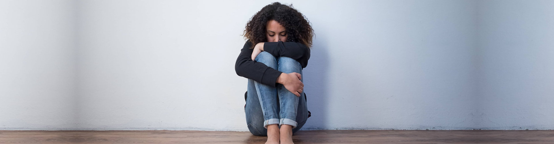 sad woman crouching on the wall